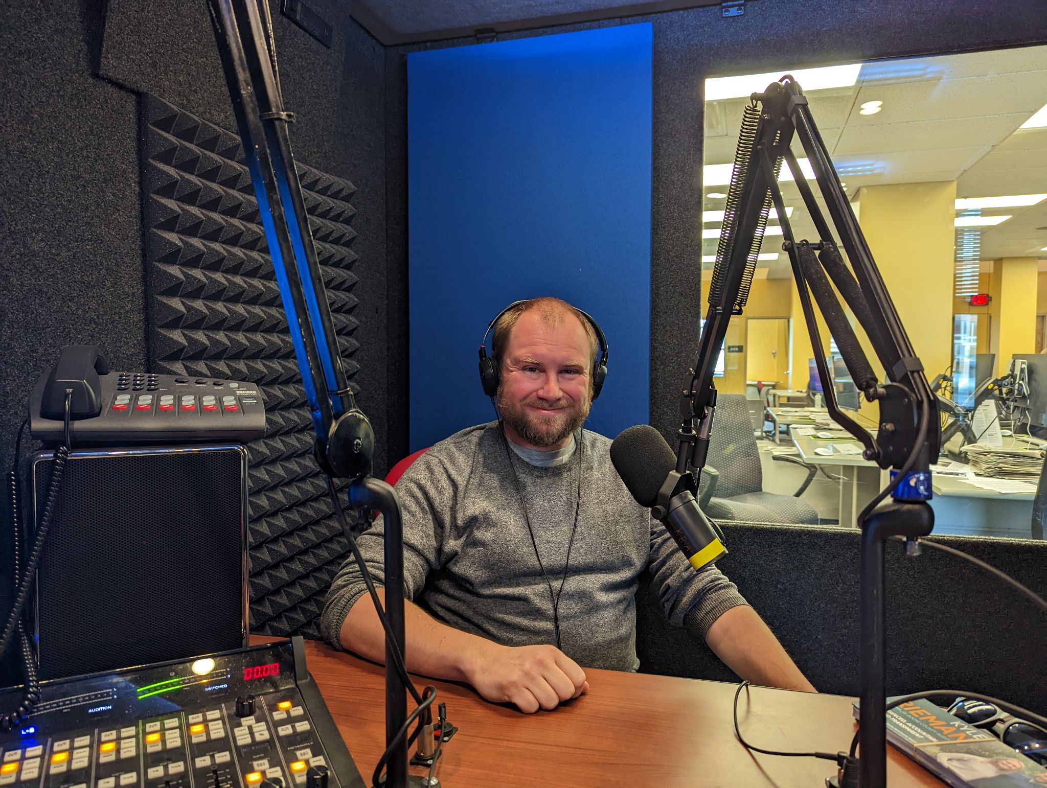 Kyle Rieman speaking in a radio studio