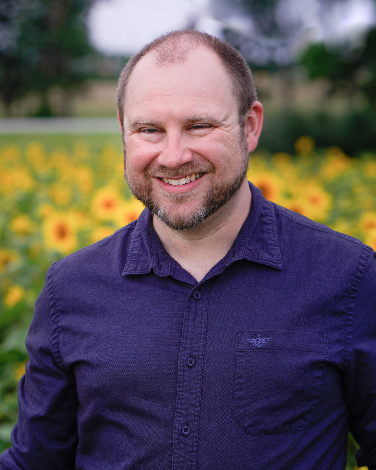 Kyle Rieman outdoors among sunflowers